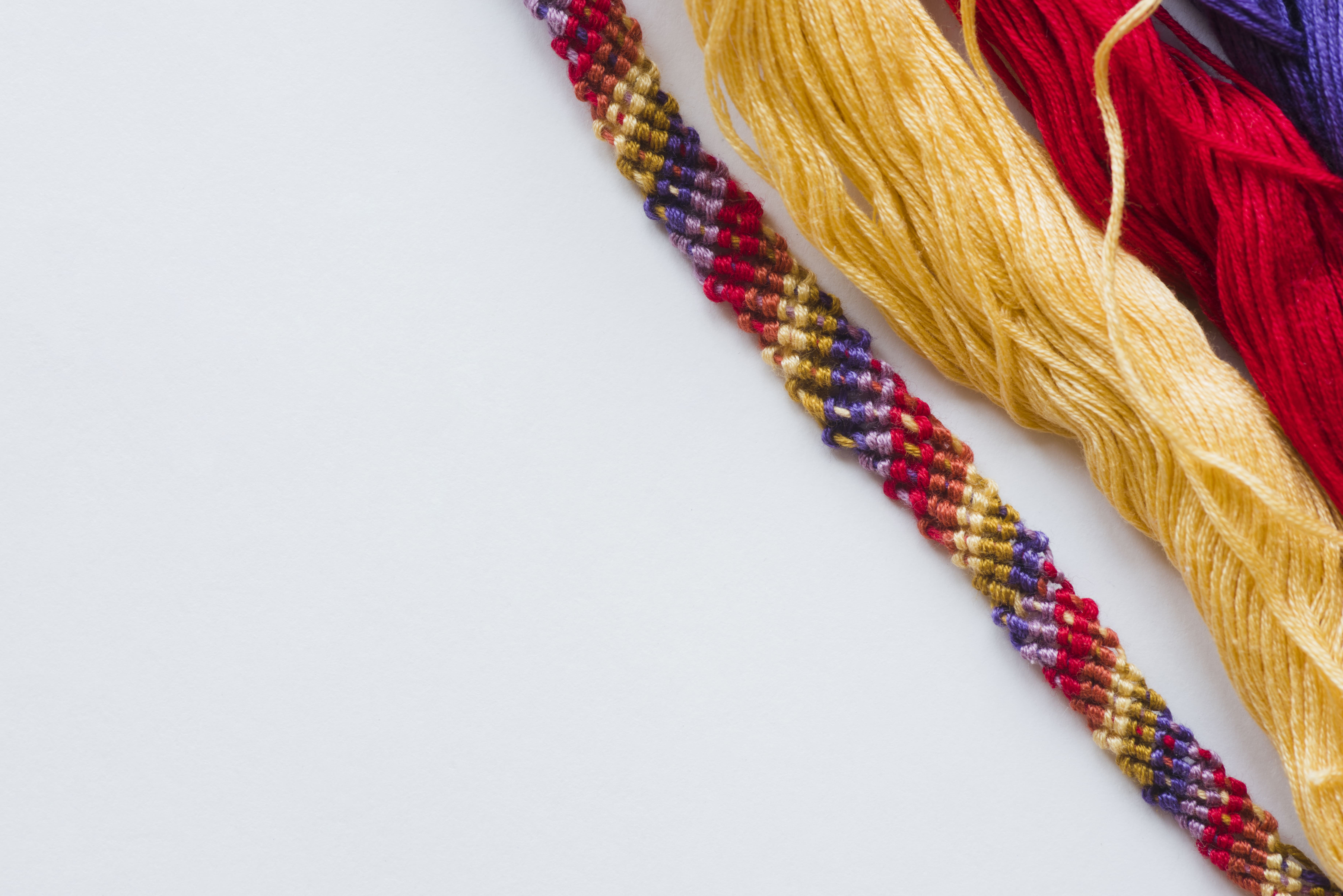 bracelet-colore-et-fils-sur-une-surface-blanche-min